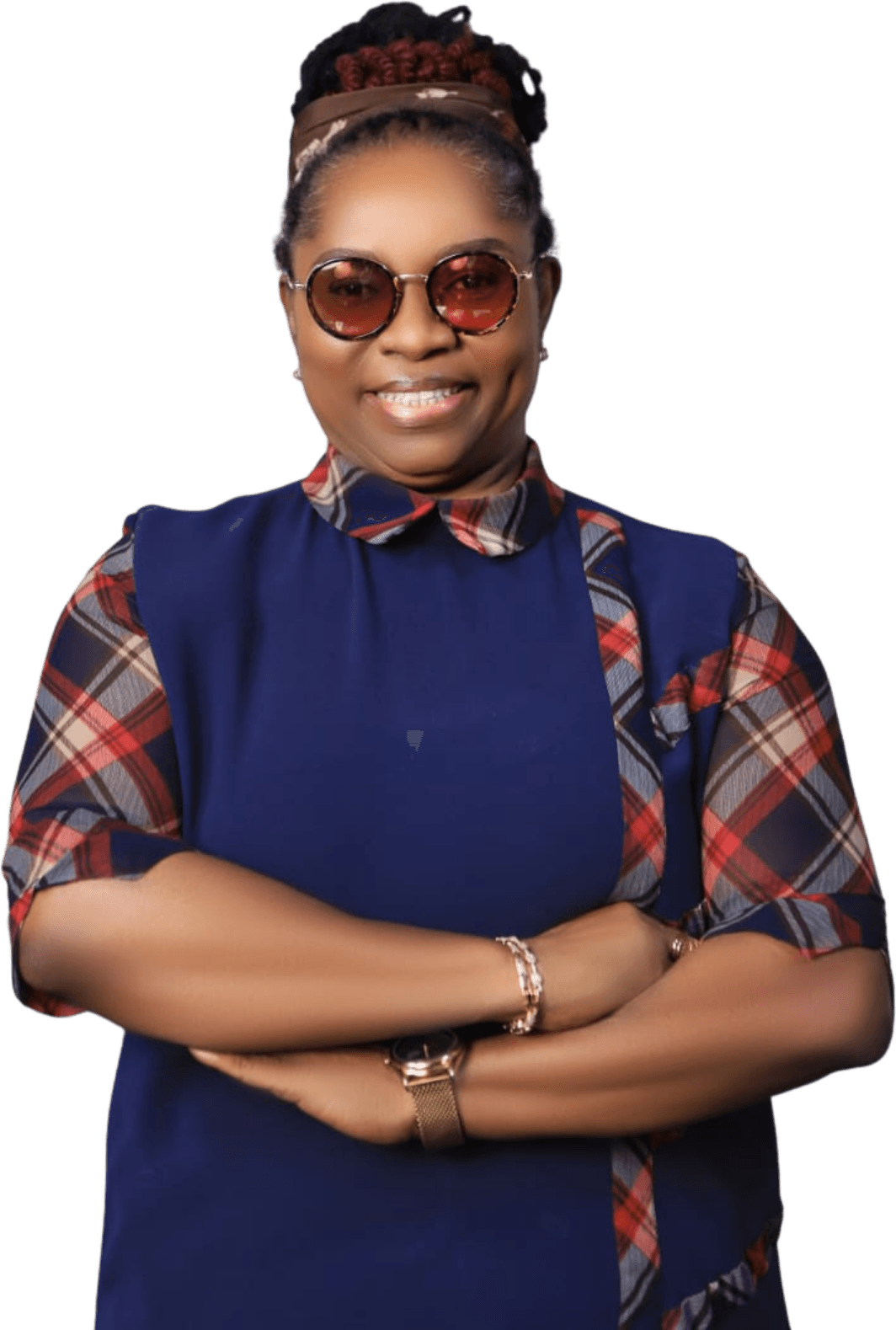 Studio portrait of Dr. Oby Nwokedi, arms folded and smiling, in a navy dress with plaid sleeves and round glasses